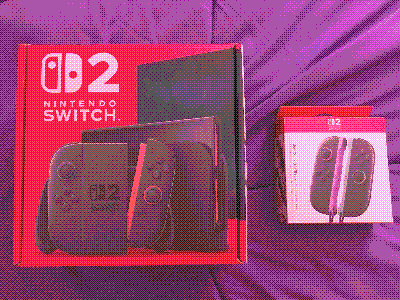 switch 2 with a purple/green switch 2 joycons on my bed